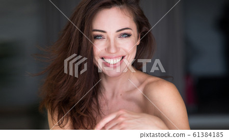 Close up portrait of a cute young woman enjoying after awakening. A happy girl dreams and looks at the you. Perfect morning at home. Close up portrait of a cute young woman enjoying after awakening. A happy girl dreams and looks at the you. Perfect morning at home. 61384185