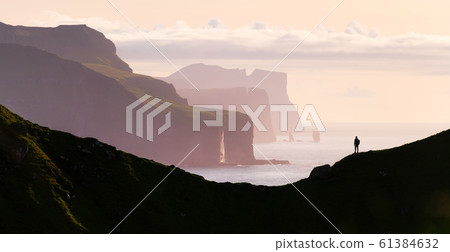 Man silhouette on background of famous Risin og Kellingin rocks 61384632
