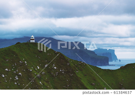 Kallur lighthouse on green hills of Kalsoy island 61384637