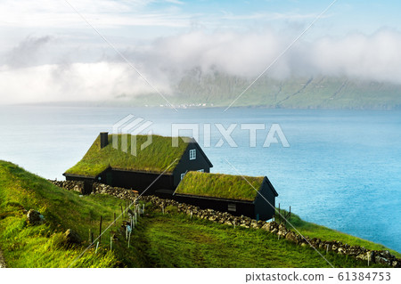 Foggy morning view of a house with typical grass roof Foggy morning view of a house with typical grass roof 61384753