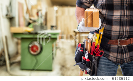 Carpenter at work on wooden boards. Carpentry. 61386112
