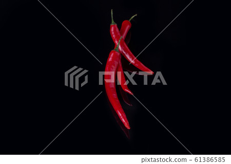 Group of red chili peppers on black background. 61386585