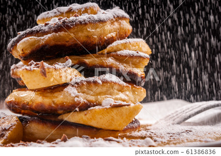 Pancakes with chocolate and banana and powdered sugar falling on top Pancakes with chocolate and banana and powdered sugar falling on top 61386836