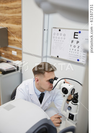 Male Optometrist Using Vision Test Equpment 61387331