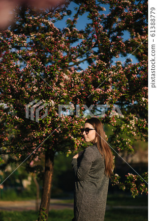 Attractive girl stand in front of beautiful blooming tree 61388779