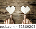 woman hand select between heart and broken heart paper cut on wooden background 61389203