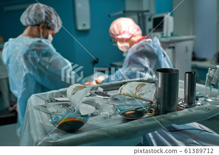 Group of surgeons in operating theater. Medical team performing surgery in operation room. Group of surgeons in operating theater. Medical team performing surgery in operation room. 61389712