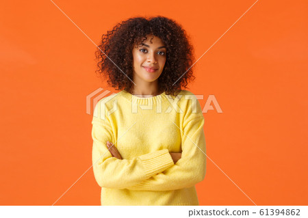 Waist-up portrait lovely young african-american female in yellow cute sweater, wrap hands around herself, cross hands on chest and smiling, give knowing look, express professionalism and confidence Waist-up portrait lovely young african-american female in yellow cute sweater, wrap hands around herself, cross hands on chest and smiling, give knowing look, express professionalism and confidence 61394862