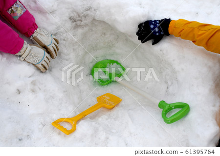 Children digging into the snowy mountains and crazy about playing with snow Children digging into the snowy mountains and crazy about playing with snow 61395764