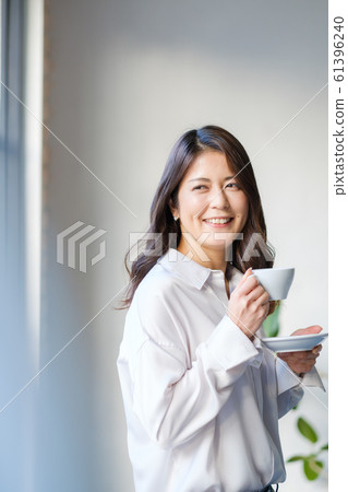 A woman relaxing by the window with a coffee cup in her hand Tea time Café Home A woman relaxing by the window with a coffee cup in her hand Tea time Café Home 61396240