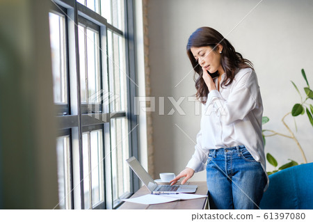 Woman standing and talking on smartphone Cafe Freelance Work 61397080