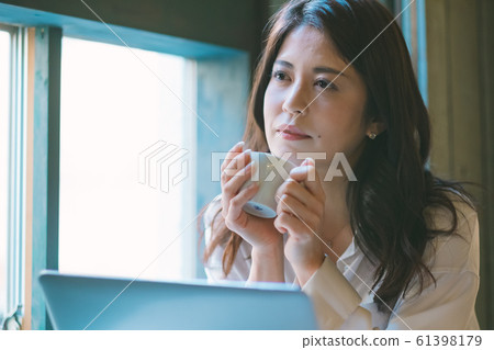 Pensive business woman by the window in a cafe 61398179