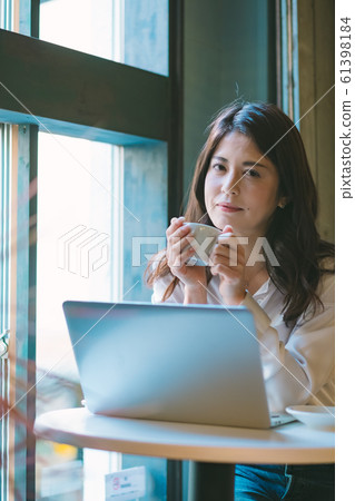 Pensive business woman by the window in a cafe Pensive business woman by the window in a cafe 61398184
