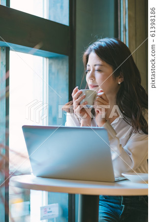 Pensive business woman by the window in a cafe Pensive business woman by the window in a cafe 61398186