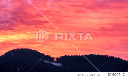 Colorful evening orange sky and silhouette of mountains at background Colorful evening orange sky and silhouette of mountains at background 61400542