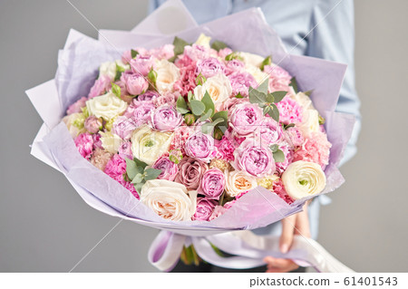 European floral shop. Beautiful bouquet of mixed flowers in womans hands. the work of the florist at a flower shop. Delivery fresh cut flower. European floral shop. Beautiful bouquet of mixed flowers in womans hands. the work of the florist at a flower shop. Delivery fresh cut flower. 61401543