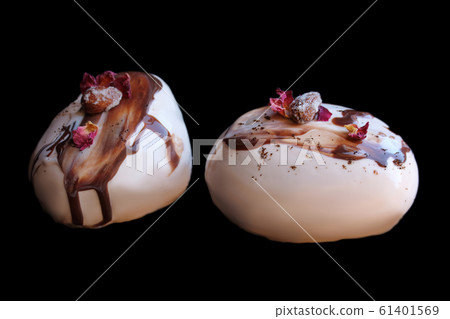 Caramel, coffee and chocolate stone desserts with almonds and rose petals on black background 61401569