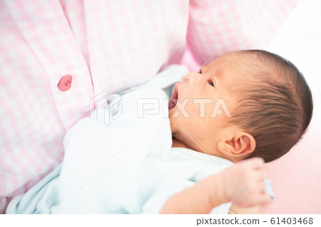 Newborn baby boy sleeping by mom Newborn baby boy sleeping by mom 61403468