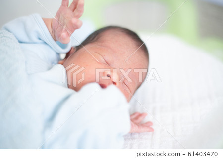 剛出生的嬰兒男孩睡在床上 剛出生的嬰兒男孩睡在床上 61403470