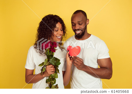 Valentine's day celebration, happy african-american couple isolated on yellow background Valentine's day celebration, happy african-american couple isolated on yellow background 61405668