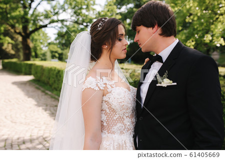 Happy groom and bride walking in the park. Charming woman with handsome man spend time together Happy groom and bride walking in the park. Charming woman with handsome man spend time together 61405669