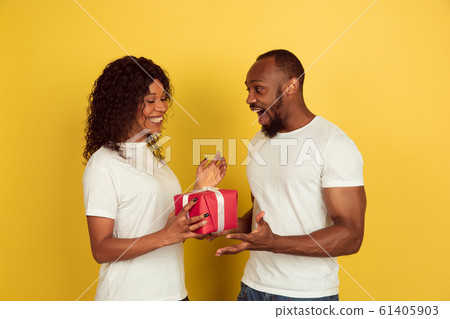 Valentine's day celebration, happy african-american couple isolated on yellow background 61405903