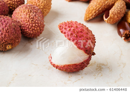 Close-up of juicy ripe lychee fruit (Litchi chinensis) on a white kitchen table. Close-up of juicy ripe lychee fruit (Litchi chinensis) on a white kitchen table. 61406448