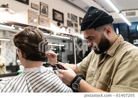 The client receives a haircut and hair styling in a beauty salon.  61407205