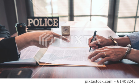 suspect with handcuffs being interviewed in 61408243