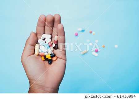 medicine and pills in hand on blue background. medicine and pills in hand on blue background. 61410994