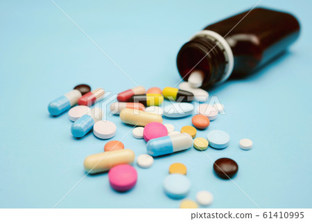 Pour the medicine out bottle on blue background Pour the medicine out bottle on blue background 61410995