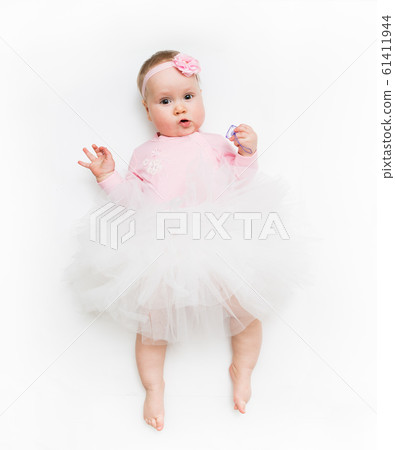 Portrait of a sweet infant wearing a pink tutu and headband bow, isolated on white in studio 61411944