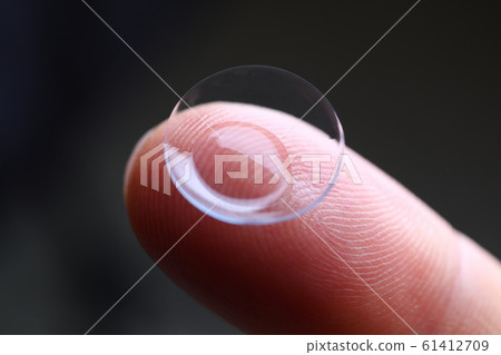 Human finger holding soft contact lens Human finger holding soft contact lens 61412709