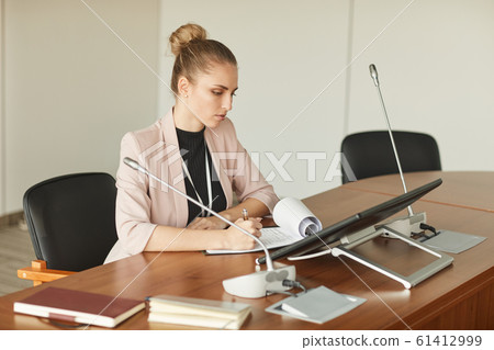 Female leader sitting at conference table 61412999