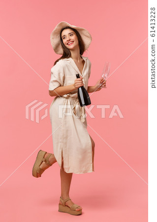 Full-length vertical shot woman on picnic, going out with girlfriend on fine sunny day in hat and dress, rushing with bottle champagne and glasses, smiling happily, standing pink background Full-length vertical shot woman on picnic, going out with girlfriend on fine sunny day in hat and dress, rushing with bottle champagne and glasses, smiling happily, standing pink background 61413228