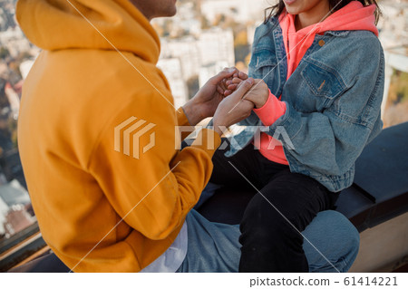 Close up of man holding girlfriend hands on roof 61414221