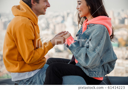 Happy young man and woman looking each other on roof 61414223