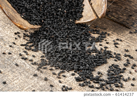 Black cumin seeds on a table, closeup Black cumin seeds on a table, closeup 61414237