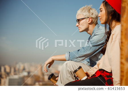Young friends is looking in front of themon roof Young friends is looking in front of themon roof 61415653
