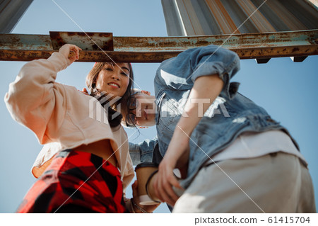 Happy guy and girl looking at camera on the roof 61415704