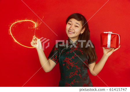 Happy Chinese New Year. Asian young girls's portrait isolated on red background Happy Chinese New Year. Asian young girls's portrait isolated on red background 61415747
