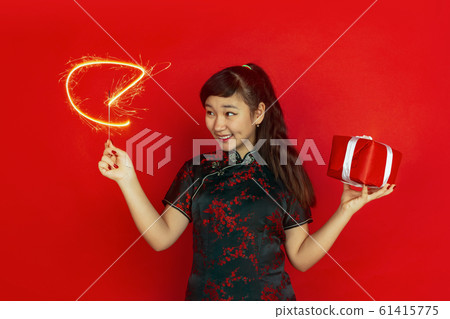 Happy Chinese New Year. Asian young girls's portrait isolated on red background 61415775