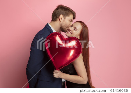 Valentine's day celebration, happy caucasian couple isolated on coral background Valentine's day celebration, happy caucasian couple isolated on coral background 61416086
