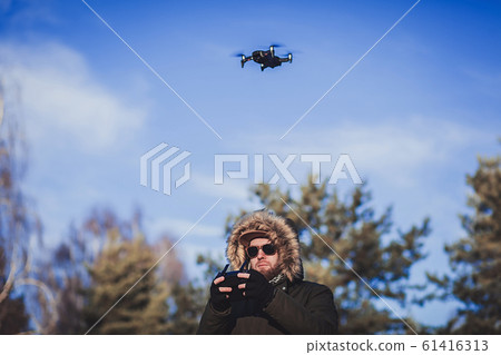 Bearded man playing with the drone 61416313