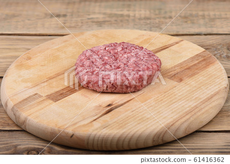 Raw pink beef cutlet on a cutting board.. Raw pink beef cutlet on a cutting board.. 61416362