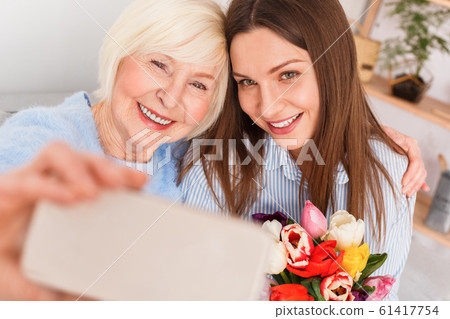 Happiness mom is hugging her daughter, making selfie Happiness mom is hugging her daughter, making selfie 61417754