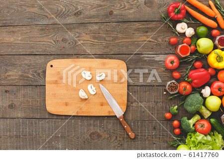 On a cutting board chopped mushroom, next to lie vegetables 61417760