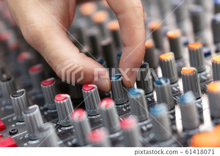 Close-up of a mixing console, hand equalizing audio channels. Professional recording studio. Working 61418071
