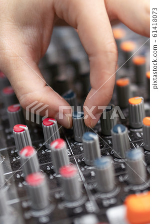 Close-up of a mixing console, hand equalizing audio channels. Professional recording studio. Working Close-up of a mixing console, hand equalizing audio channels. Professional recording studio. Working 61418073