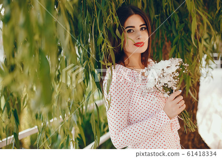 Cute girl walking in a summer park 61418334